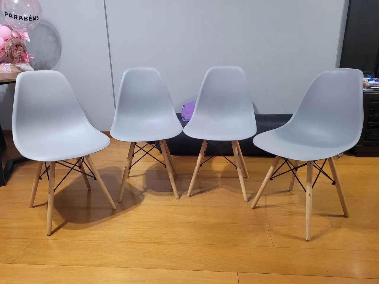 4 Cadeiras Eames Eiffel com base em madeira.
