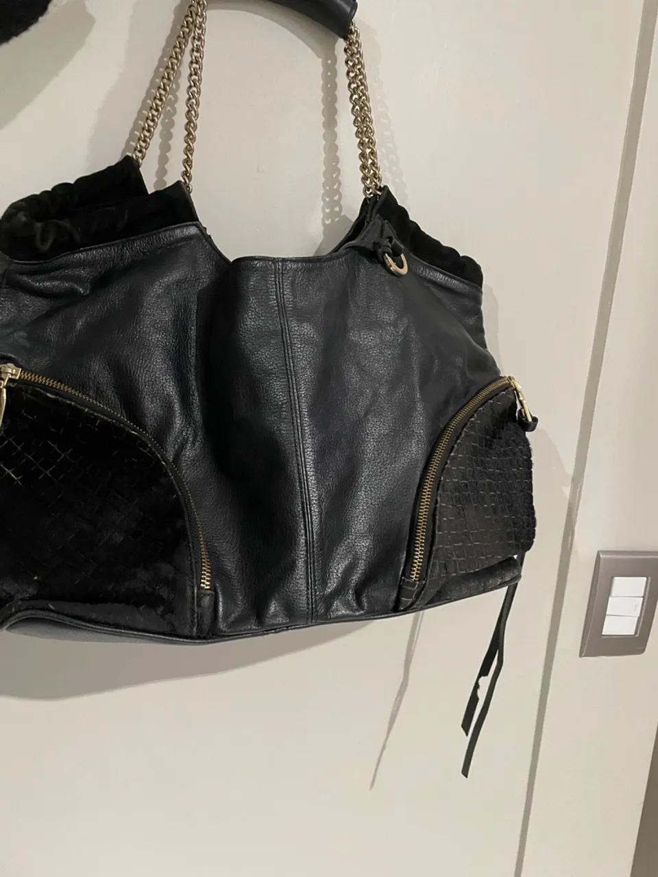 Bolsa de couro preta com detalhes em corrente e zíperes