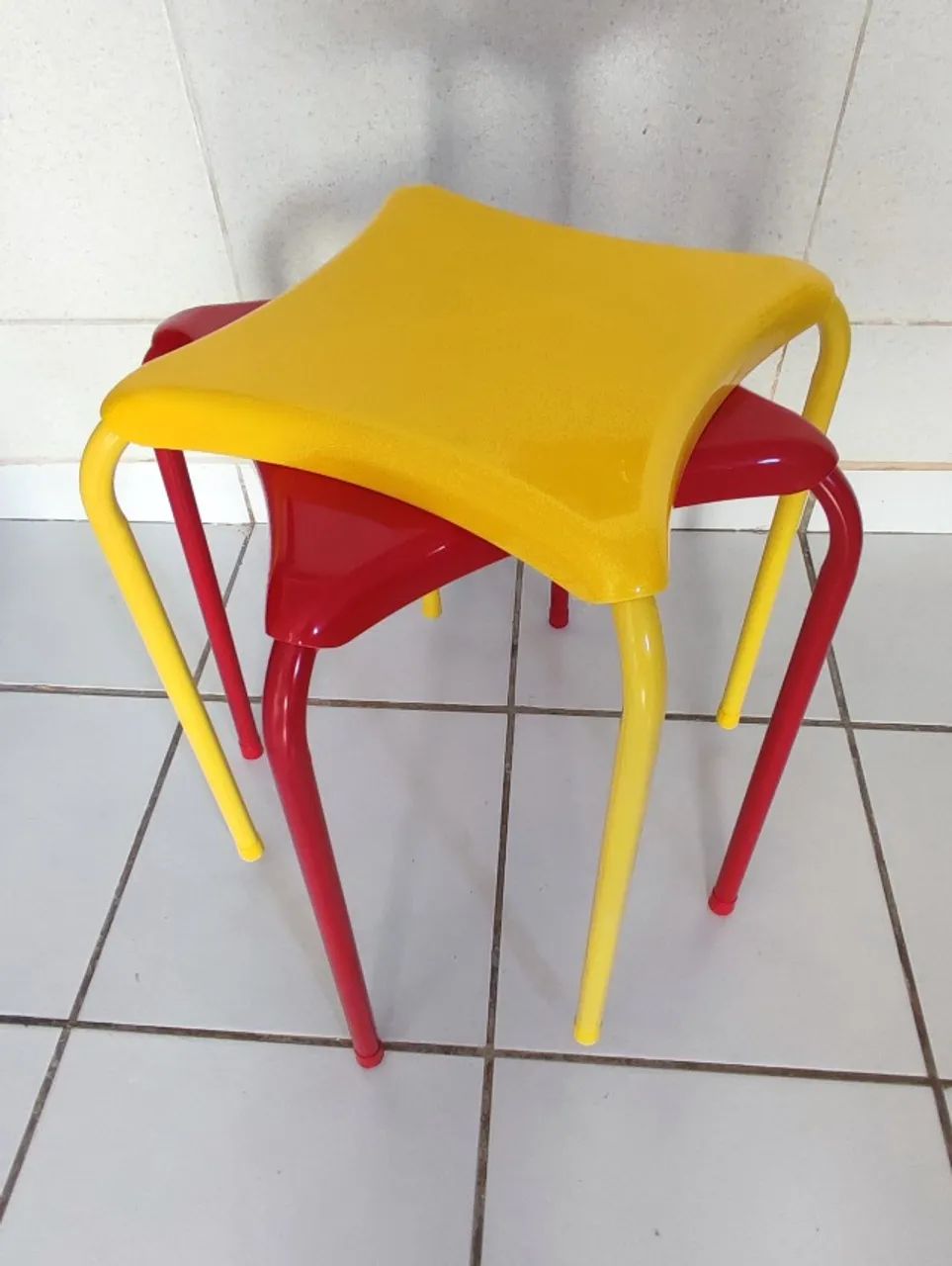2 bancos em metal amarelo e vermelho.