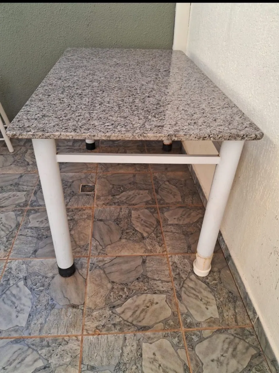 Mesa com tampo de granito e estrutura branca