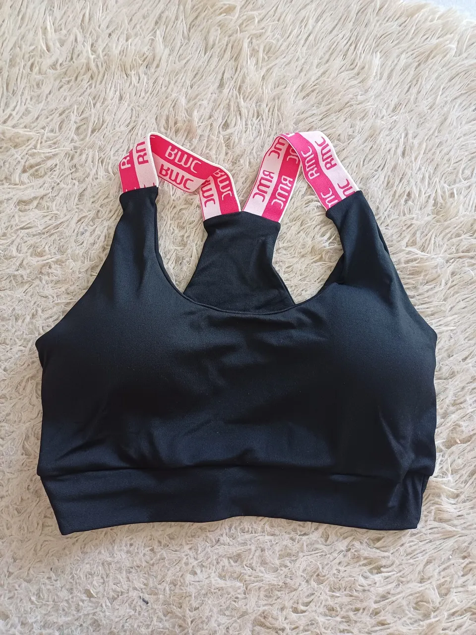 Top esportivo preto com detalhes em rosa