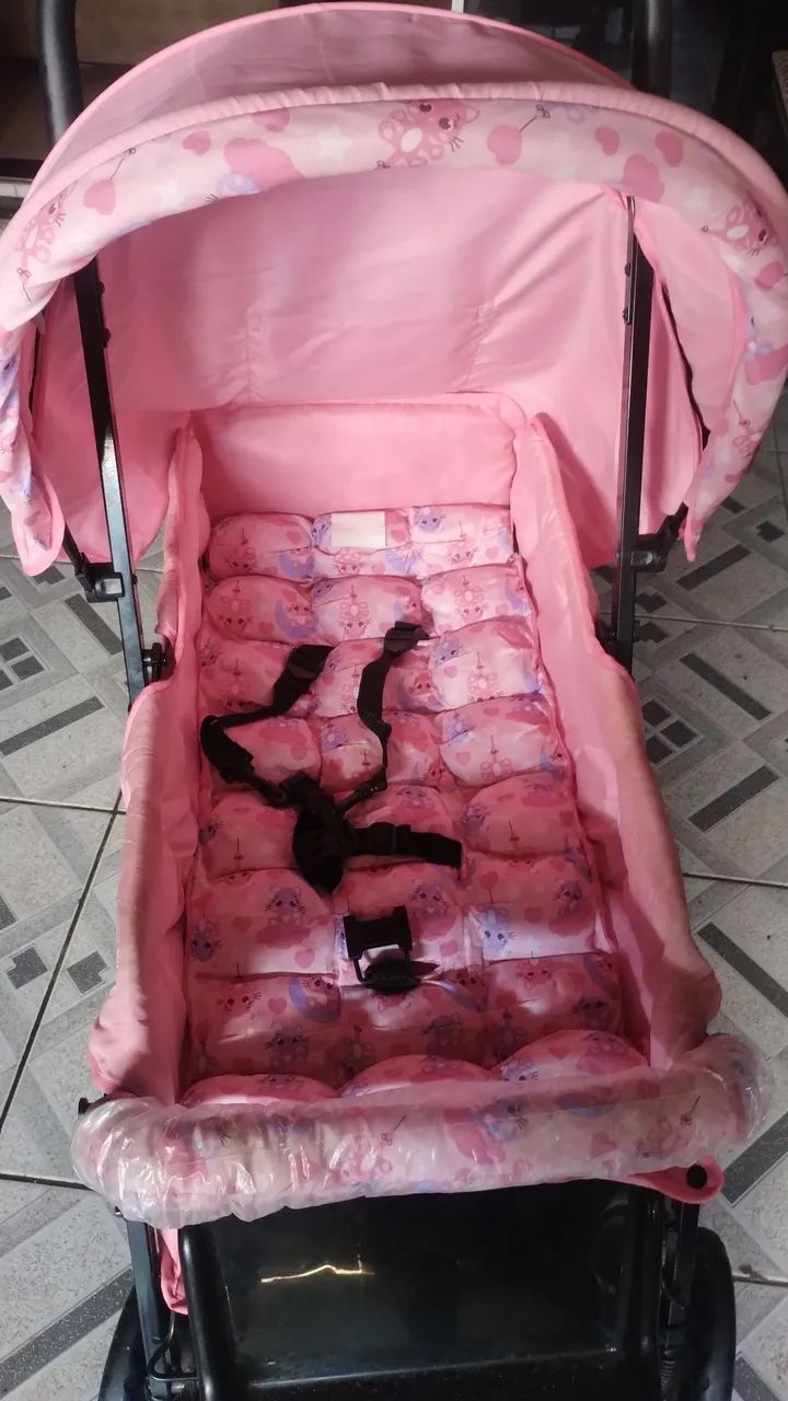 Carrinho de bebê rosa com capota e almofada