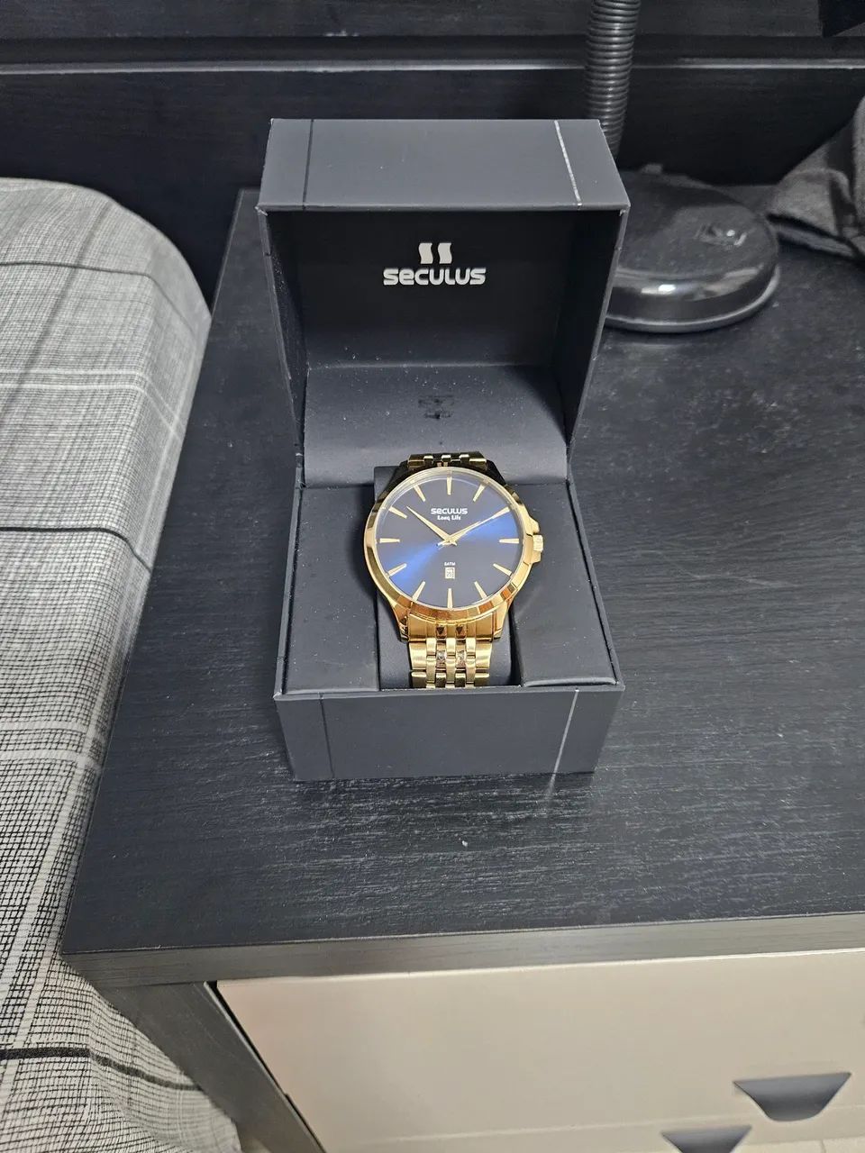 Relógio Secculus dourado com fundo azul