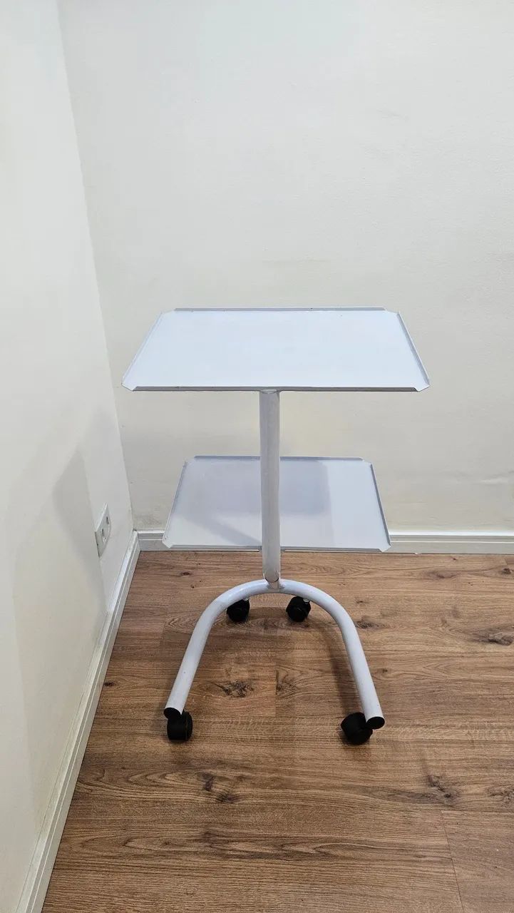Mesa auxiliar tubular com duas prateleiras e rodinhas.