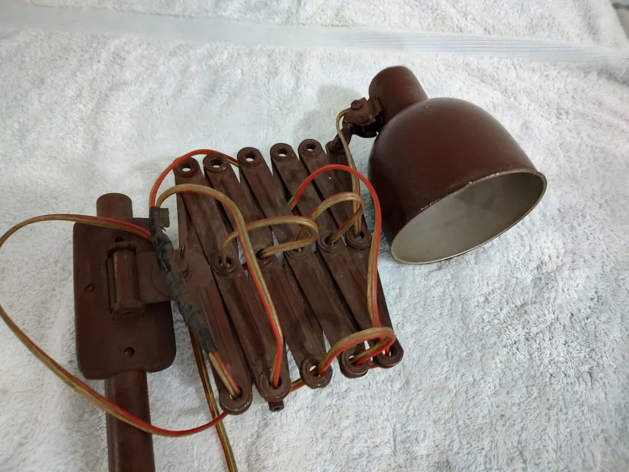 Antiga luminária pantográfica de mesa em metal marrom.