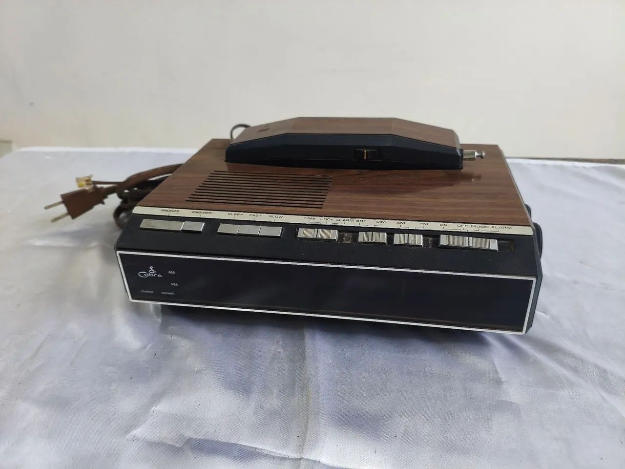 Rádio relógio e telefone antigo.