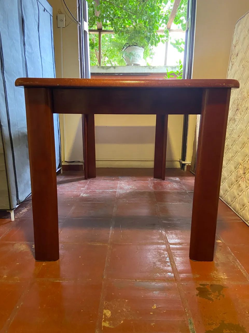 Mesa de jantar em madeira com tampo de vidro.