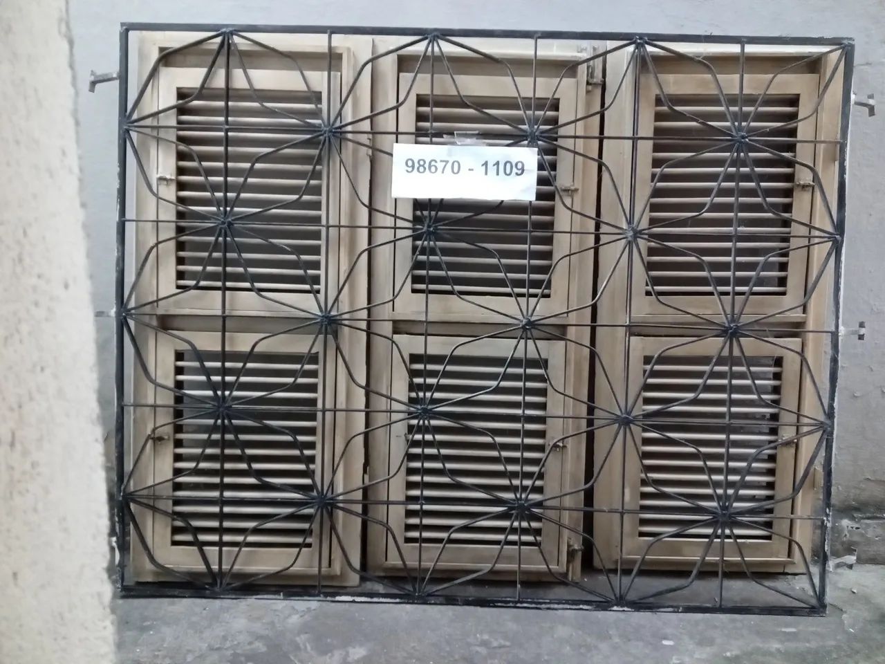 Janela de madeira com grade de ferro