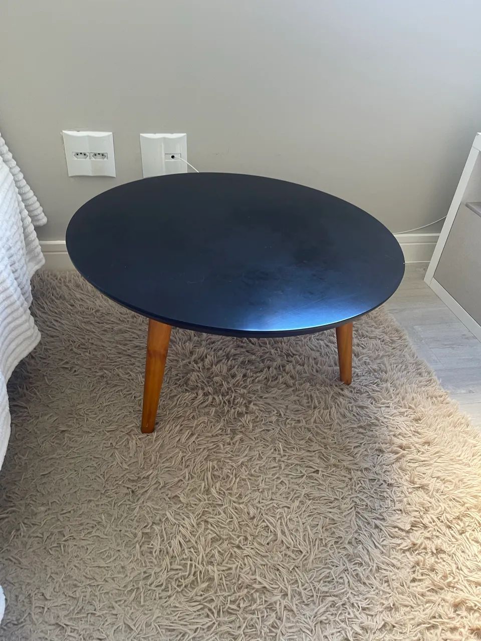 Mesa de centro preta com estrutura de madeira