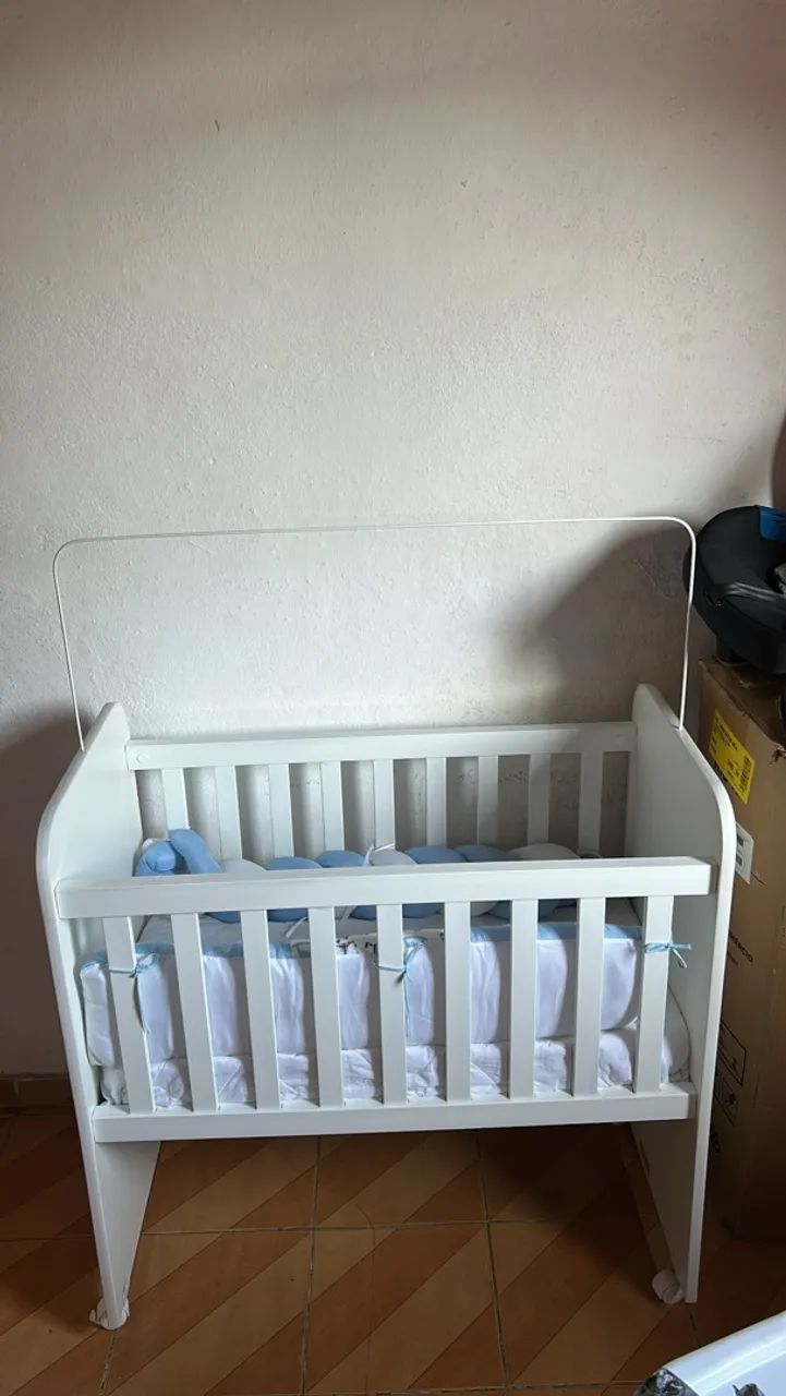 Berço de bebê branco com rodinhas e kit berço