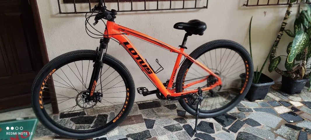 BIKE CAIRU LOTUS ARO 29, 21 MARCHAS, FREIO A DISCO, QUADRO 17.5, LARANJA/PRETO (COM NOTA)