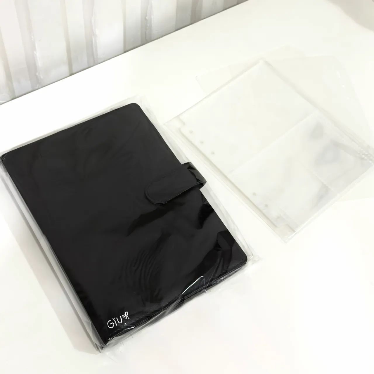 binder A5 macaron preto/black usado com folhas e base de proteção.