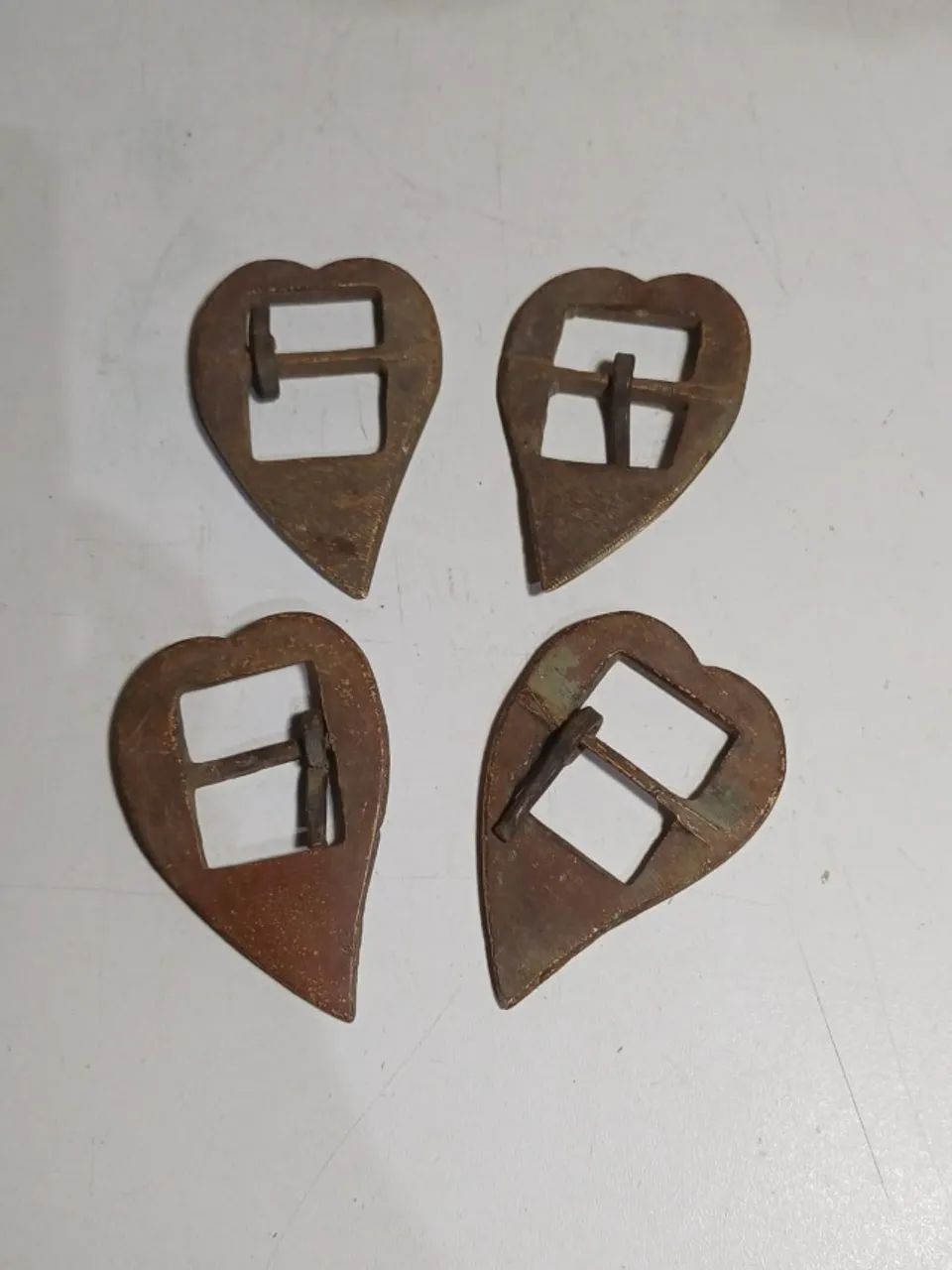 Lote com quatro fivelas em metal amarelo em formato de coração 