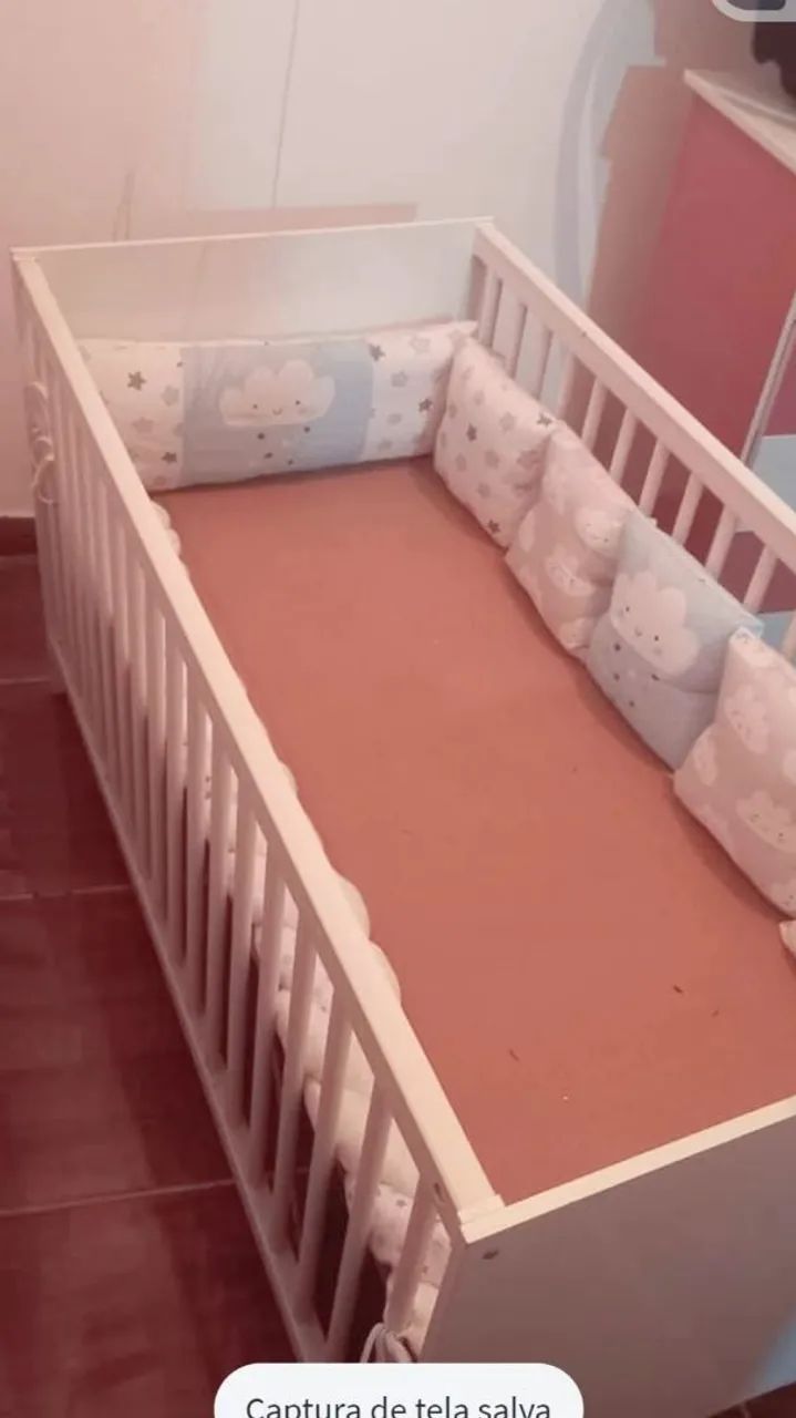 Berço de bebê branco completo.