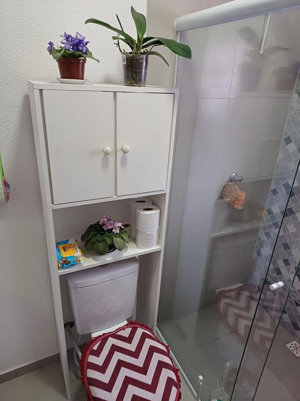 Móvel para banheiro com porta papel higiênico e plantas