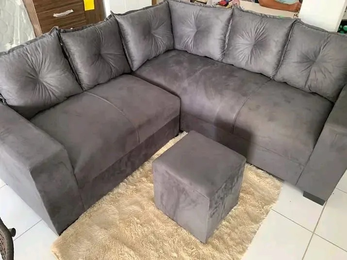 Sofá de canto cinza com puff
