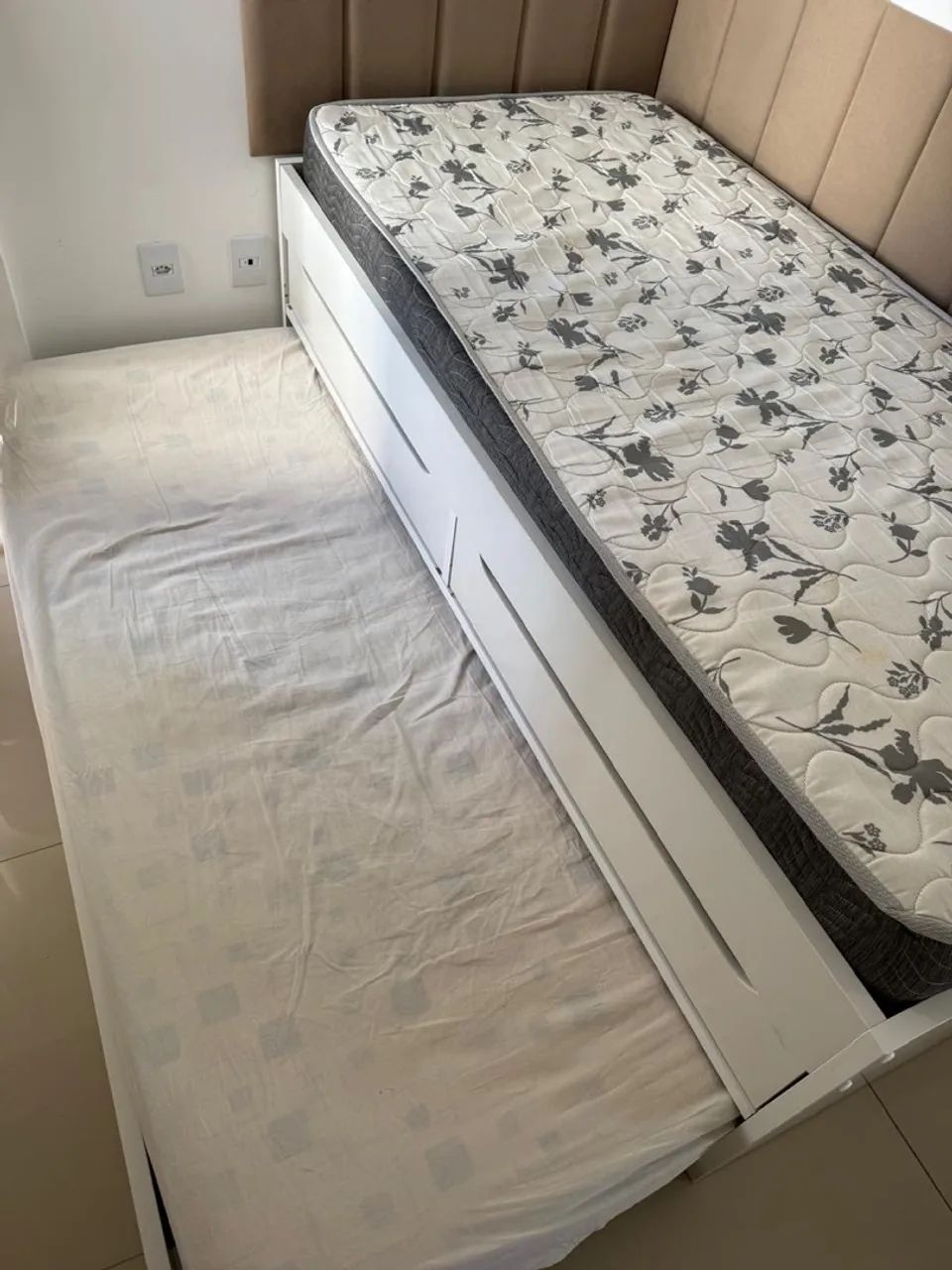 Cama de solteiro com cama auxiliar.