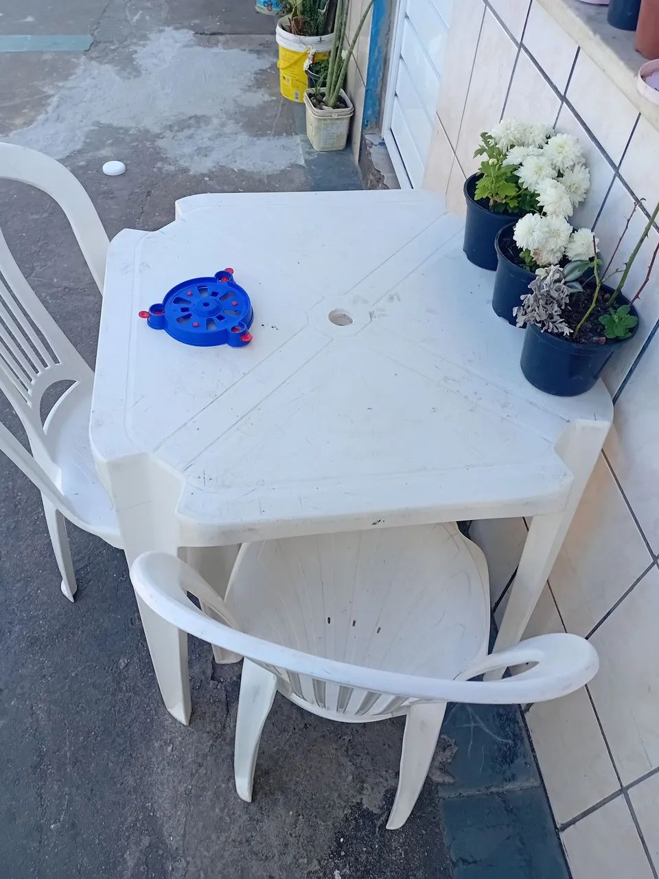 Vendo uma mesa e duas cadeiras brancas.