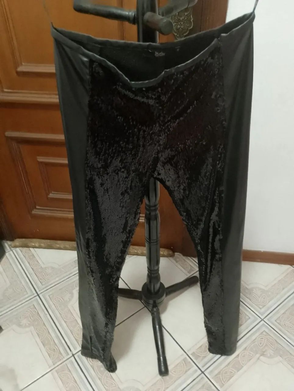 Calça de paetê é da DASLU 