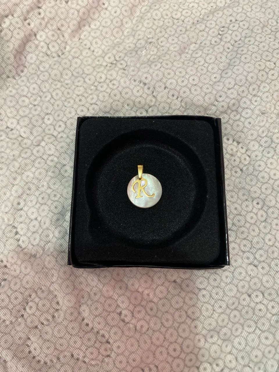 Pingente em madre pérola e ouro.