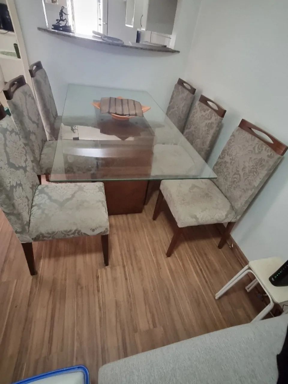 Mesa de jantar com tampo de vidro e seis cadeiras.