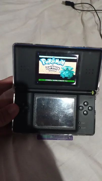 Nintendo DS com dois jogos originais, um flashcard de GBA e cabo USB para carregar.
