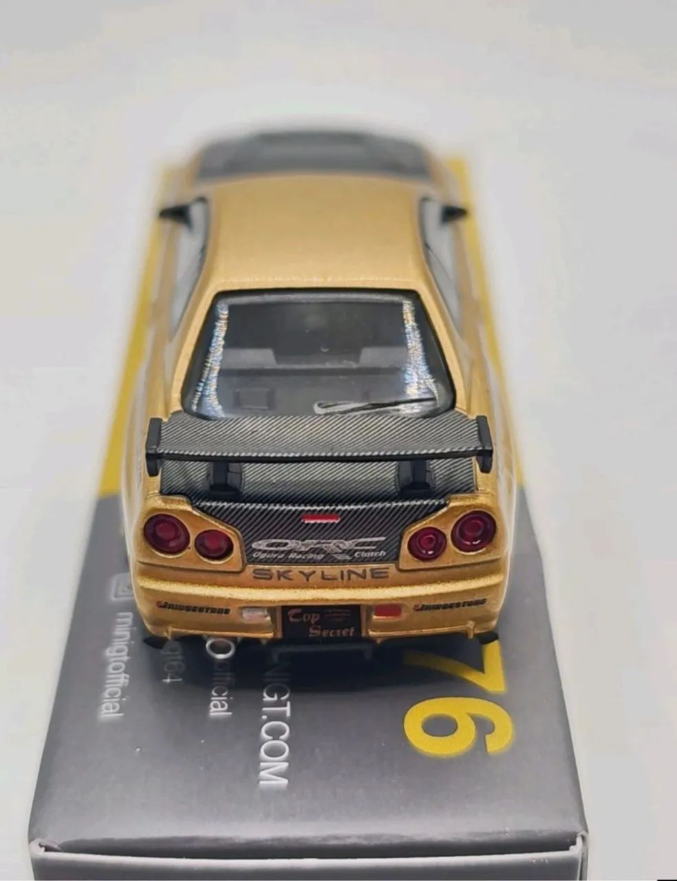 Mini GT Nissan Skyline GT-R (R34) Top Secret Gold Exclusivo do