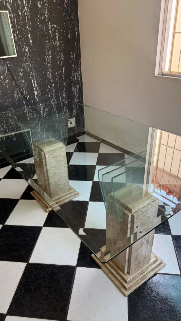 Mesa de vidro com pés de pedra.