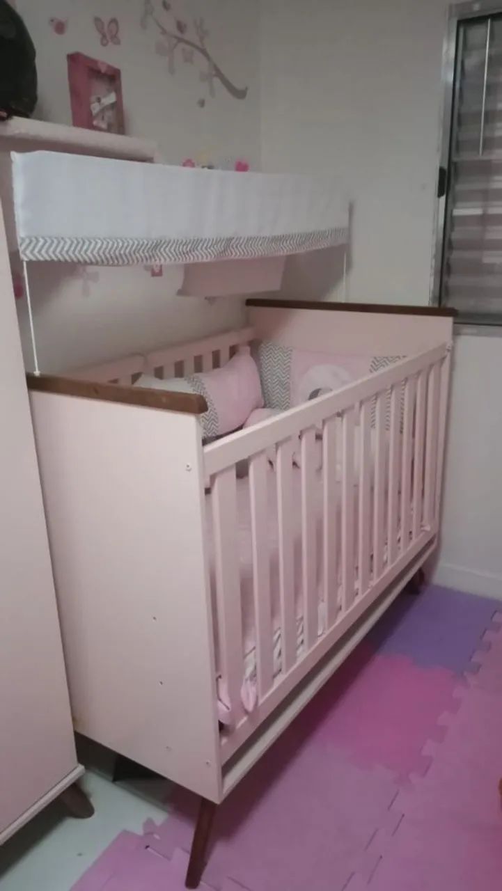 Berço de bebê rosa com mosquiteiro