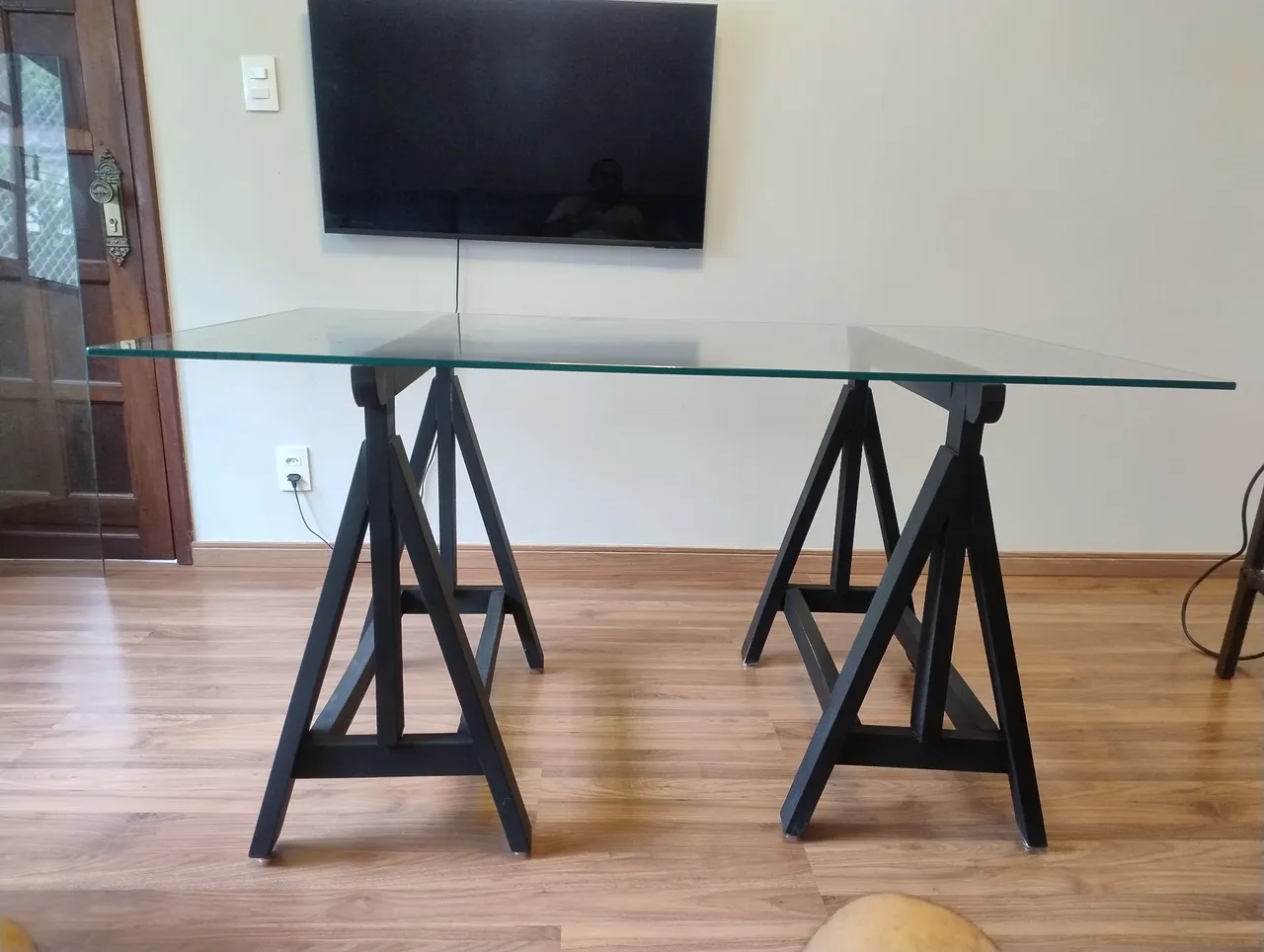 Mesa de vidro com cavaletes pretos