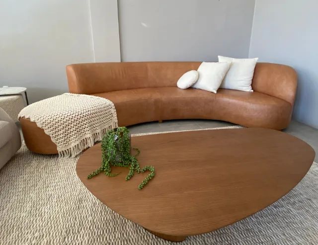 Sofá curvo em tecido bouclé laranja, design moderno e aconchegante. Perfeito para compor a