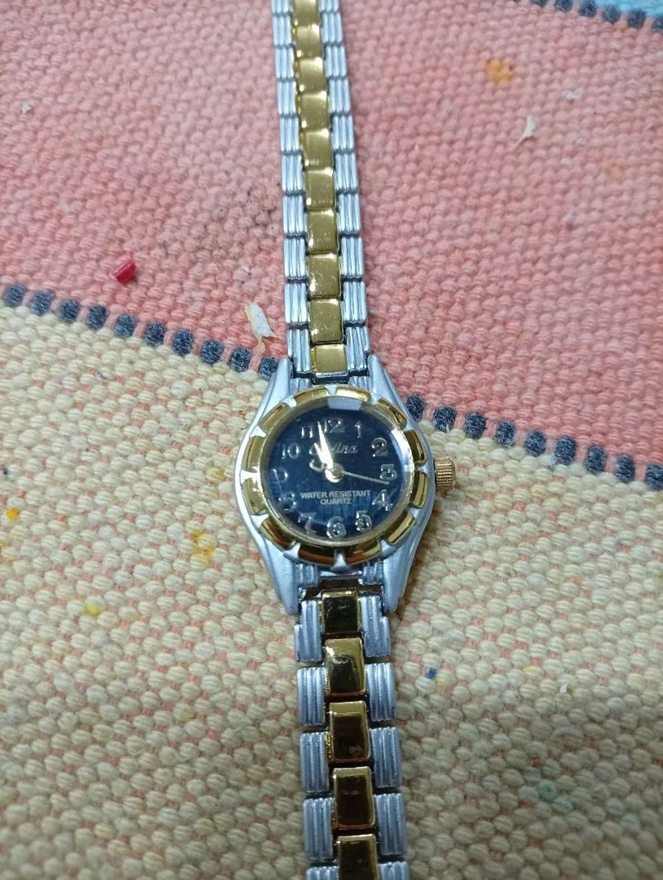 Relógio pulso cadina prata e dourado.