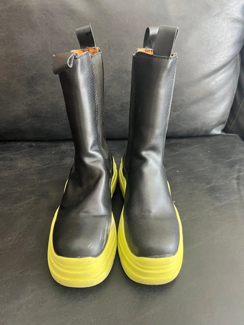 Botas pretas com sola verde limão