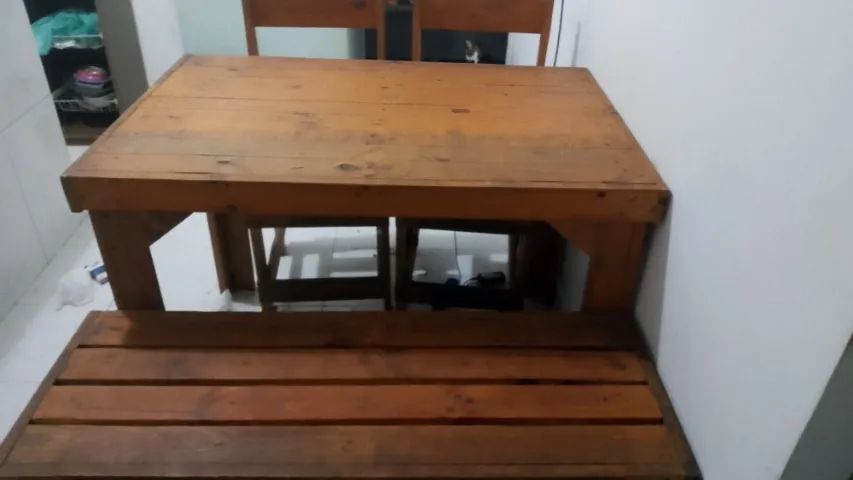 Mesa de madeira com duas cadeiras e um banco