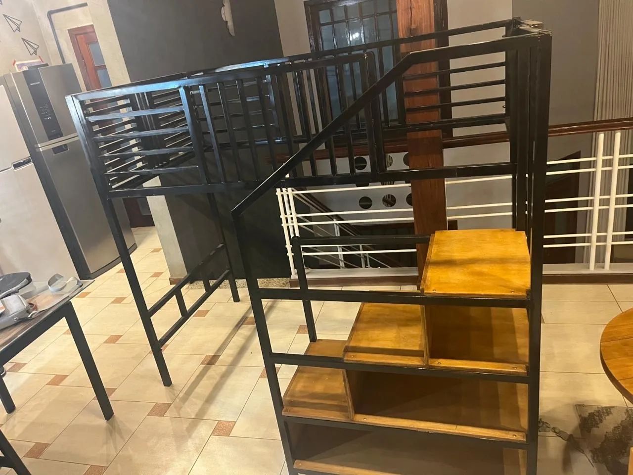 Cama beliche com escada móvel em prateleiras.