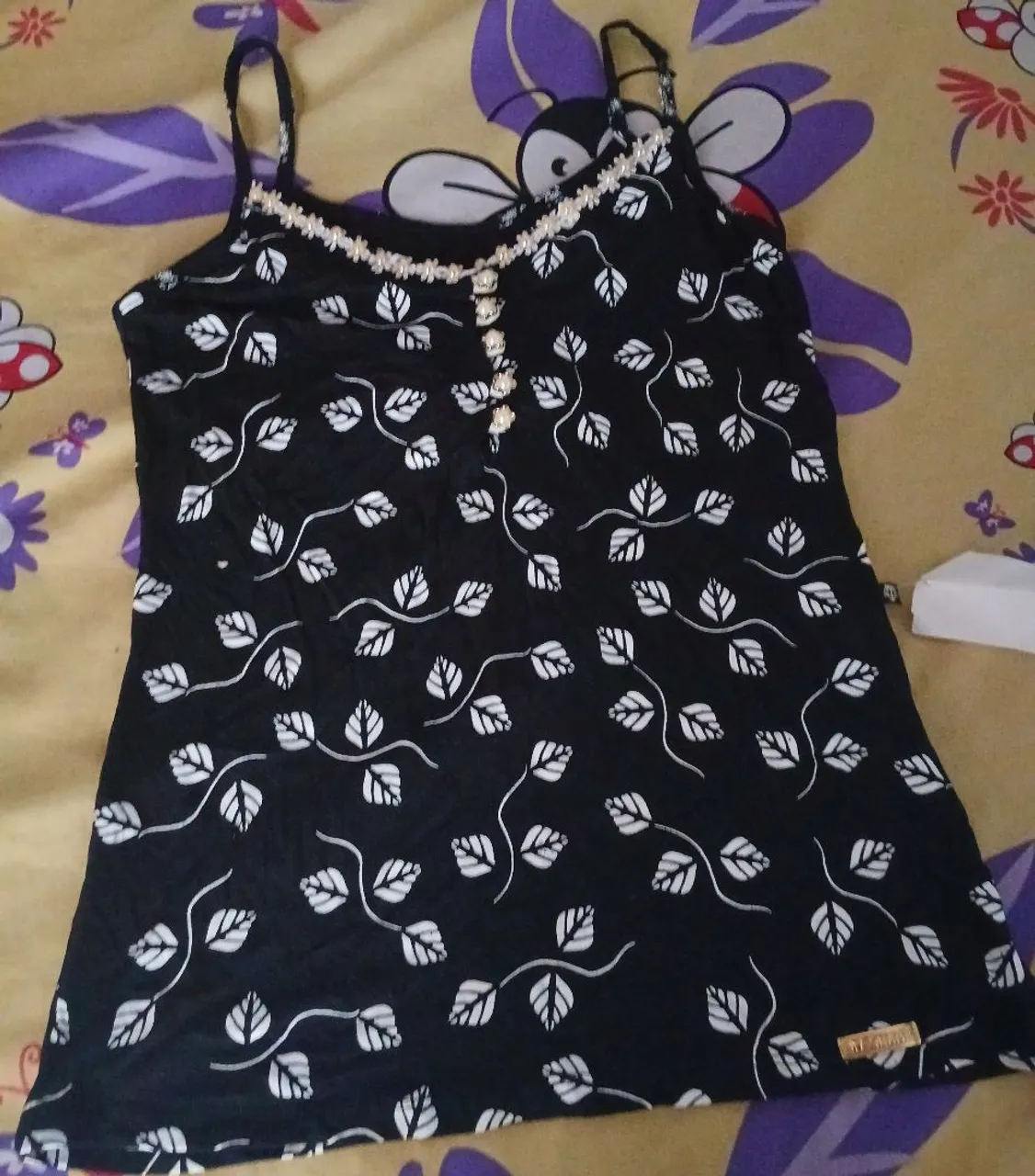 Camiseta regata preta com detalhes e estampa floral