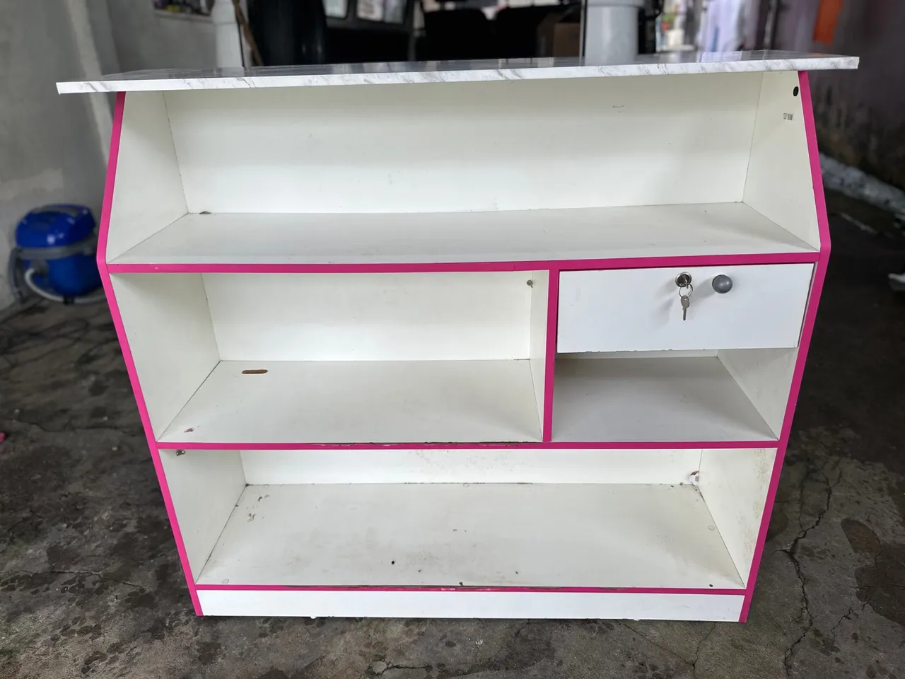 Balcão comercial branco com detalhes rosa
