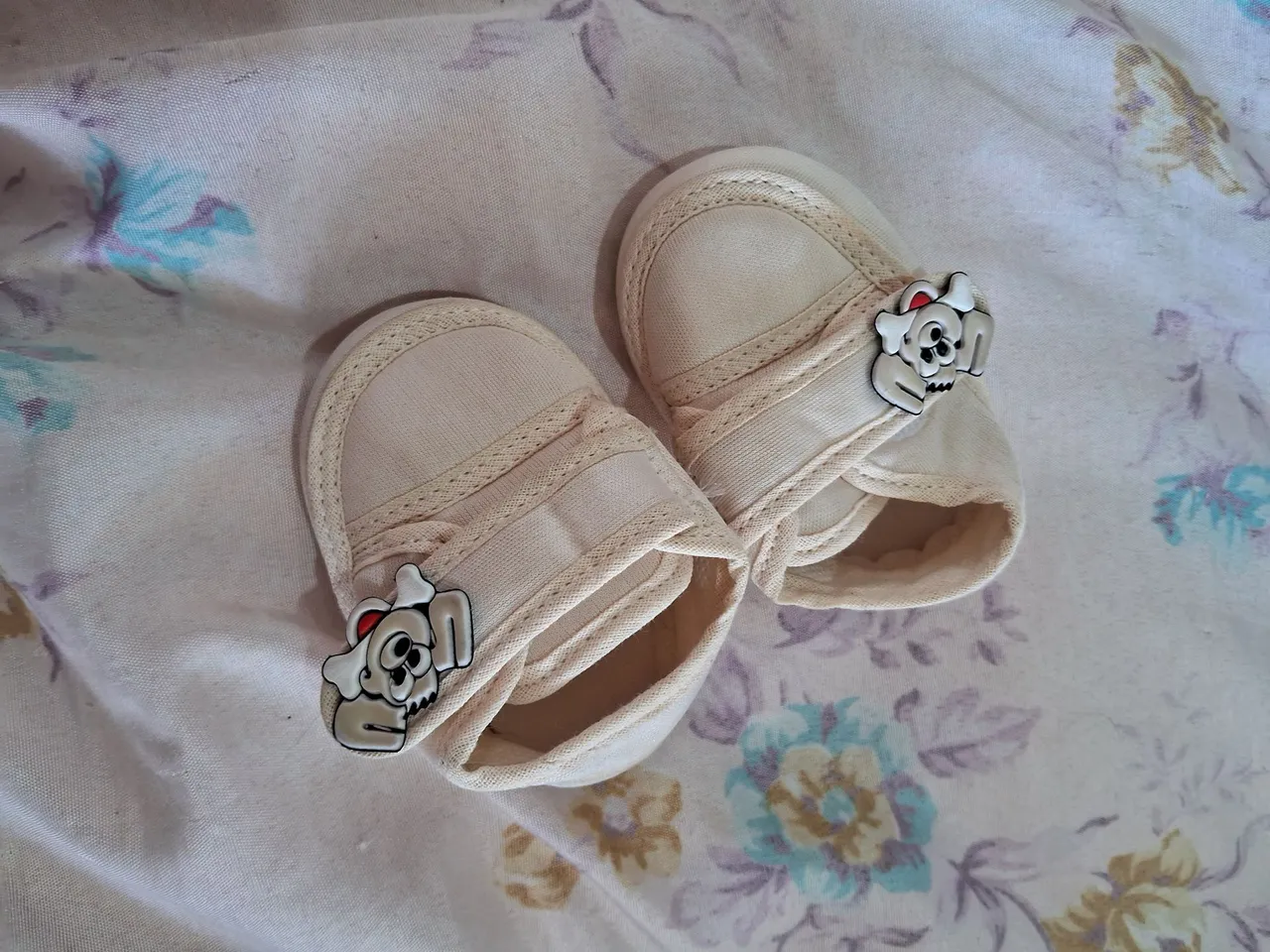 Sapatinhos de bebê bege com detalhe de cachorrinho