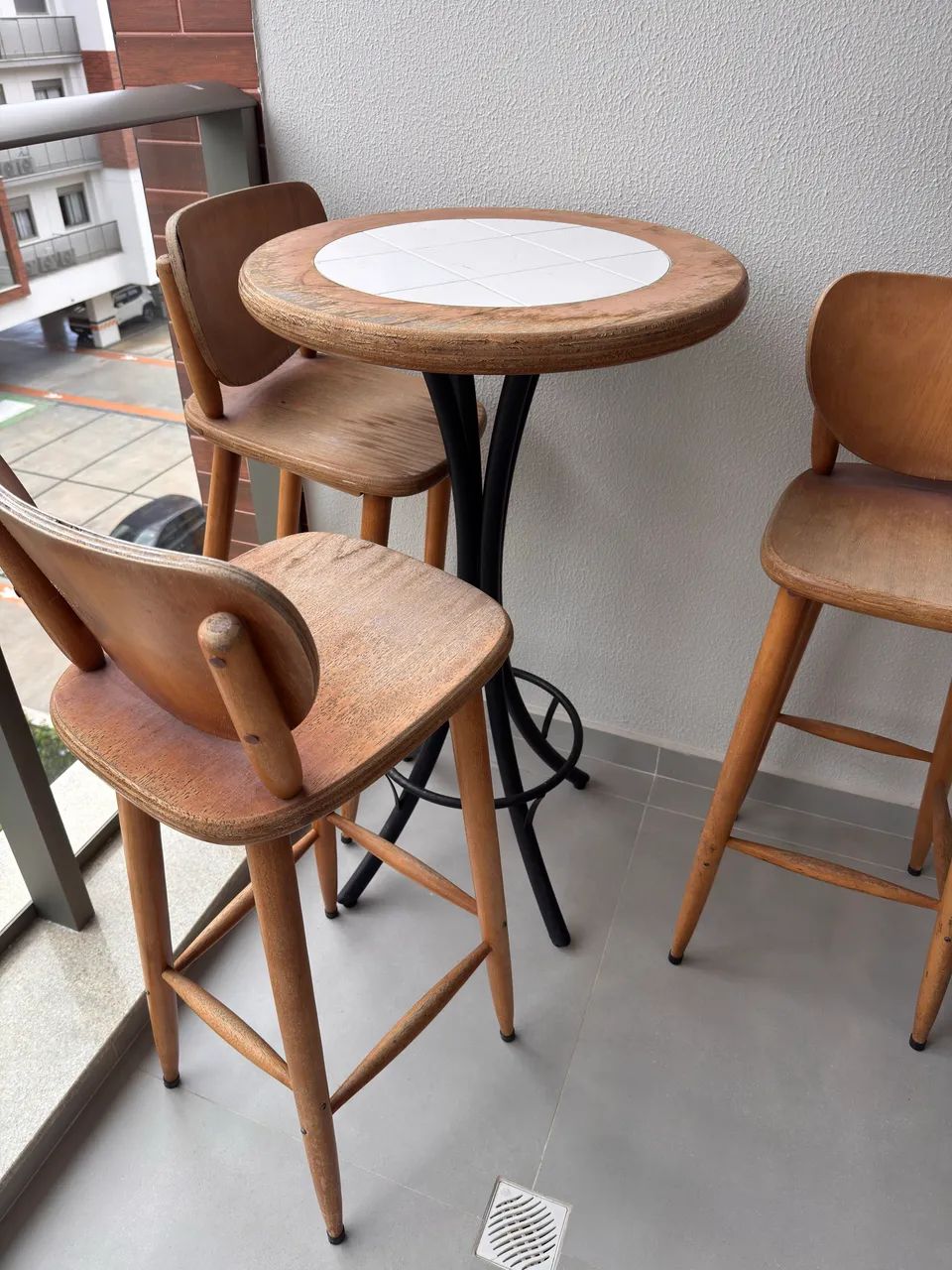 Mesa alta de varanda com três banquetas