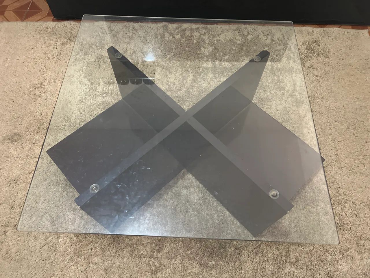 Mesa de centro com tampo de vidro temperado e base de madeira na cor marrom escuro 