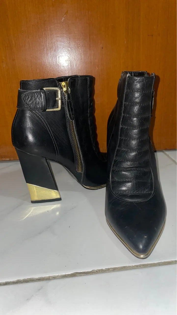 Botas de couro pretas com detalhes dourados