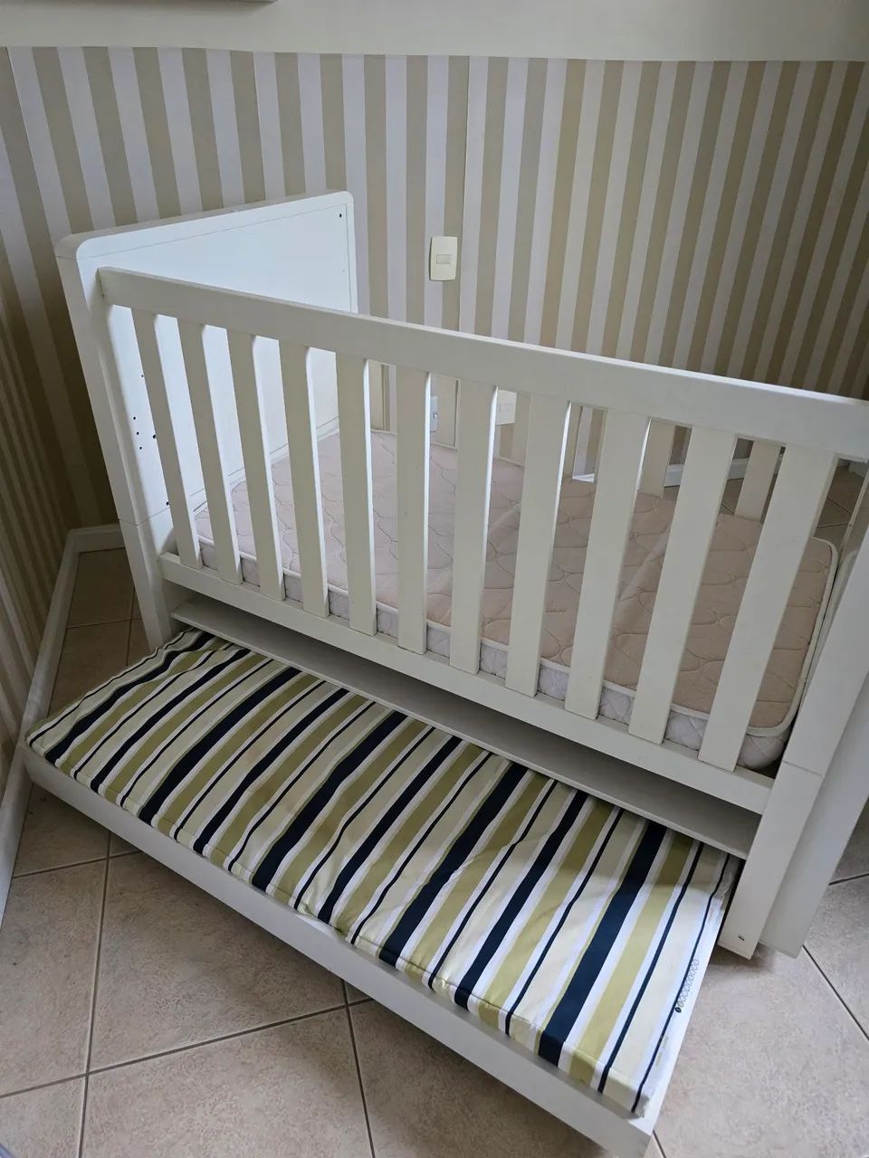 Berço cama com cama adicional e dois colchoes de tecido impermeavel.