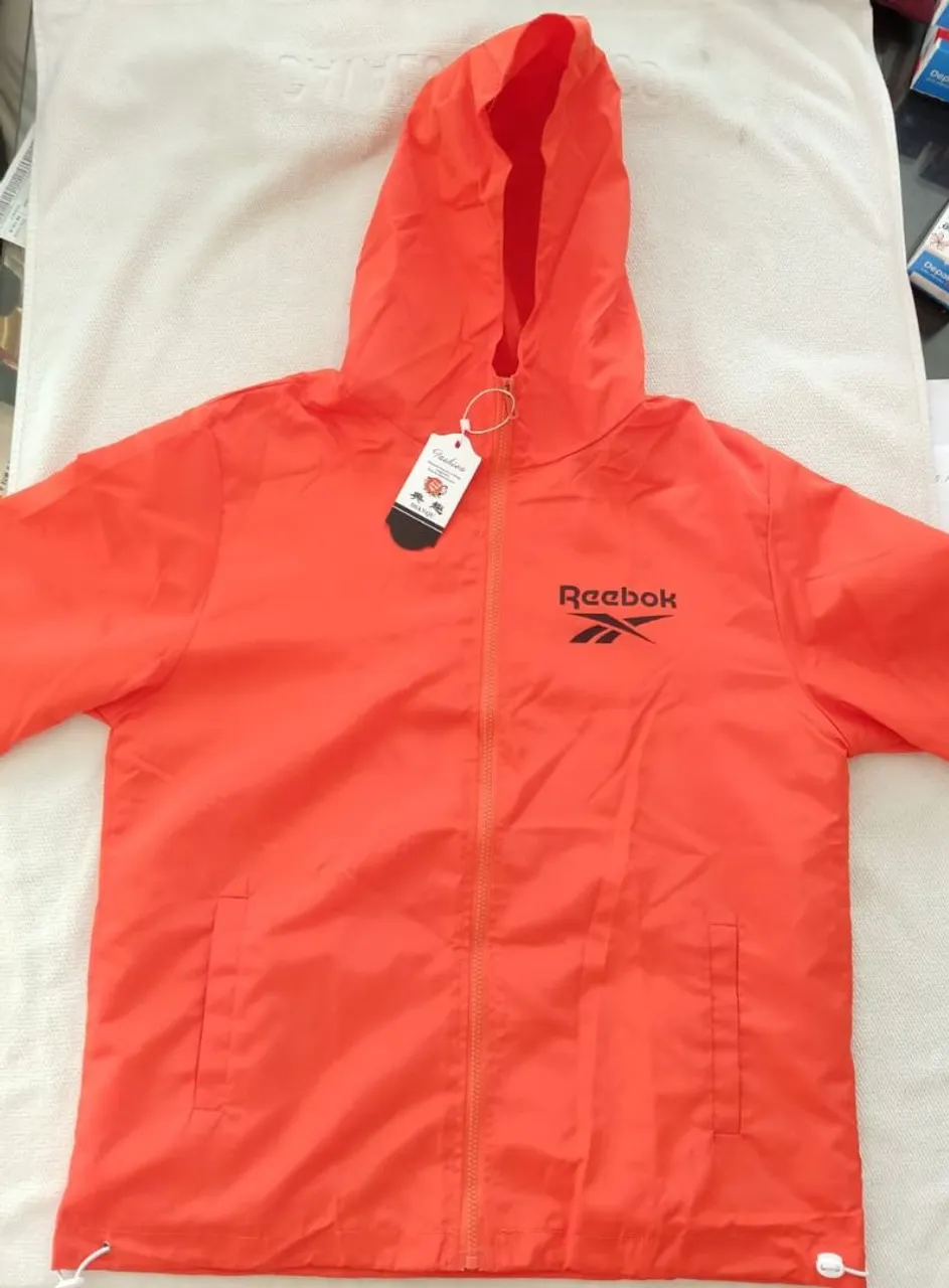 Jaqueta corta vento laranja com capuz Reebok.