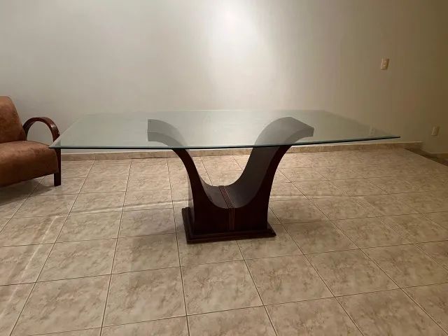 Mesa de vidro com base curvada em madeira