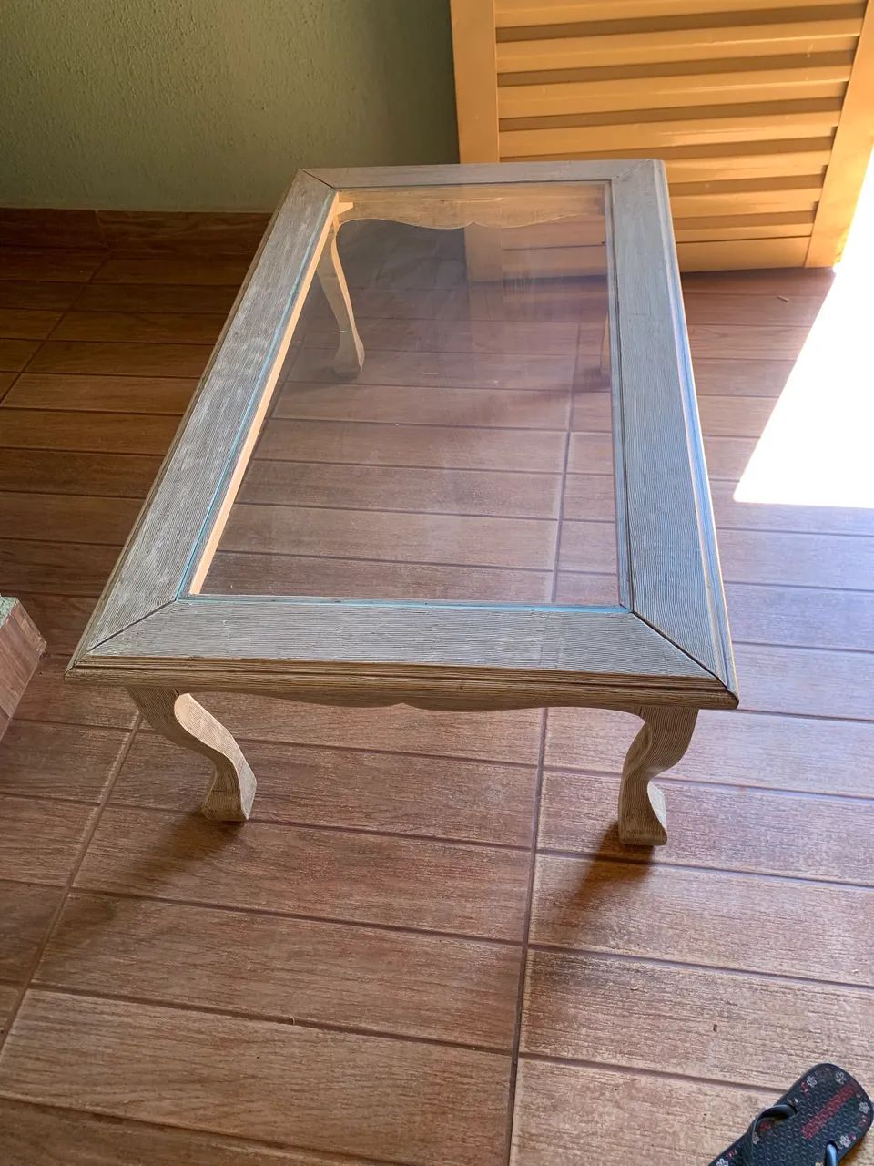 Esta é uma mesa de centro clássica de madeira com tampo de vidro e pés curvados. - Foto 2
