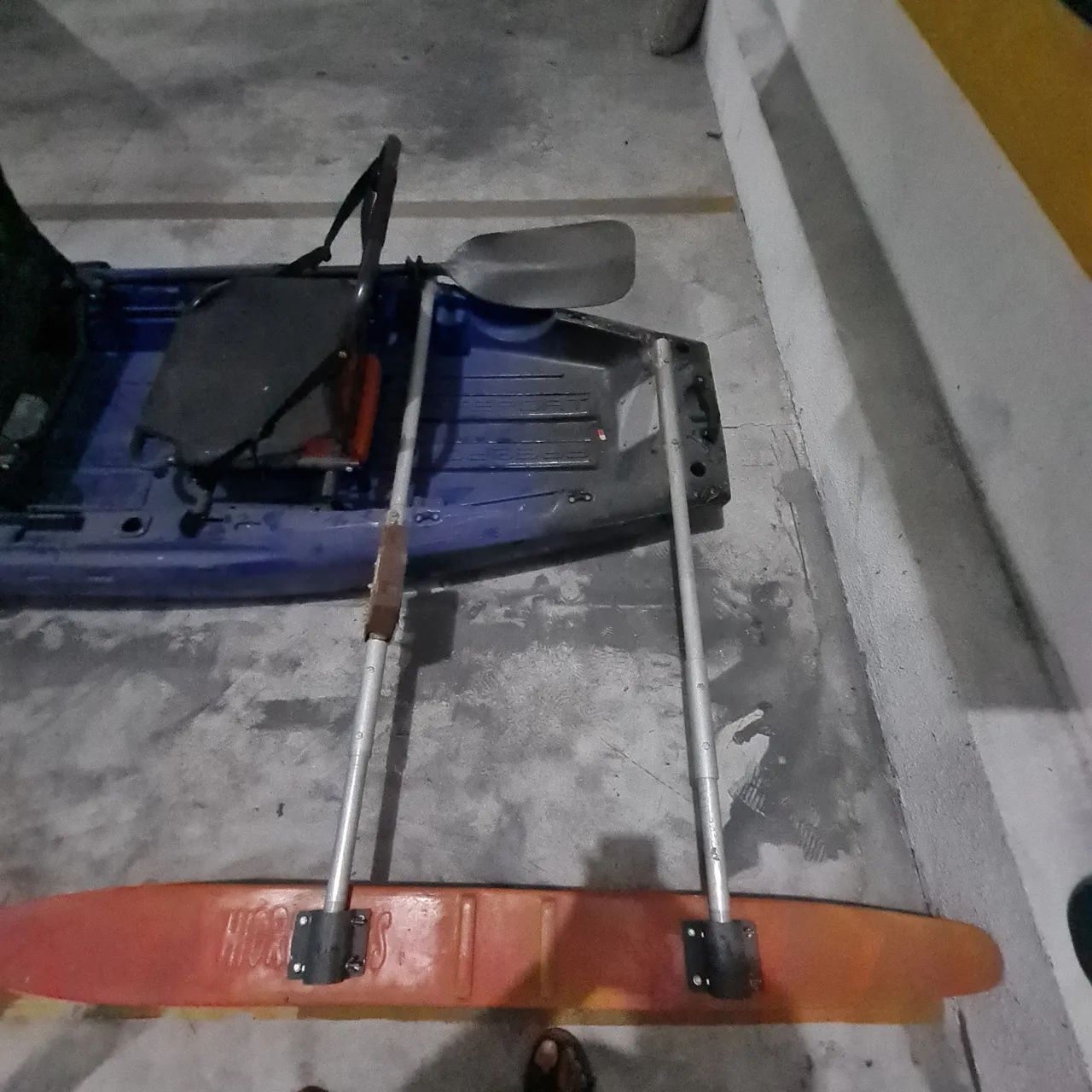 Double kayak with lateral stabilizers and paddle.