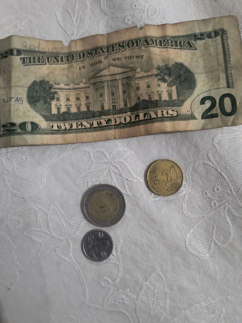 Moedas e dólar, moeda de 10 centavos de 1989 , uma moeda de 2 euro ,e uma moeda de 20 cent