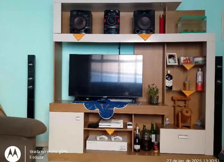 Estante de maeira com prateleiras e espaço para TV