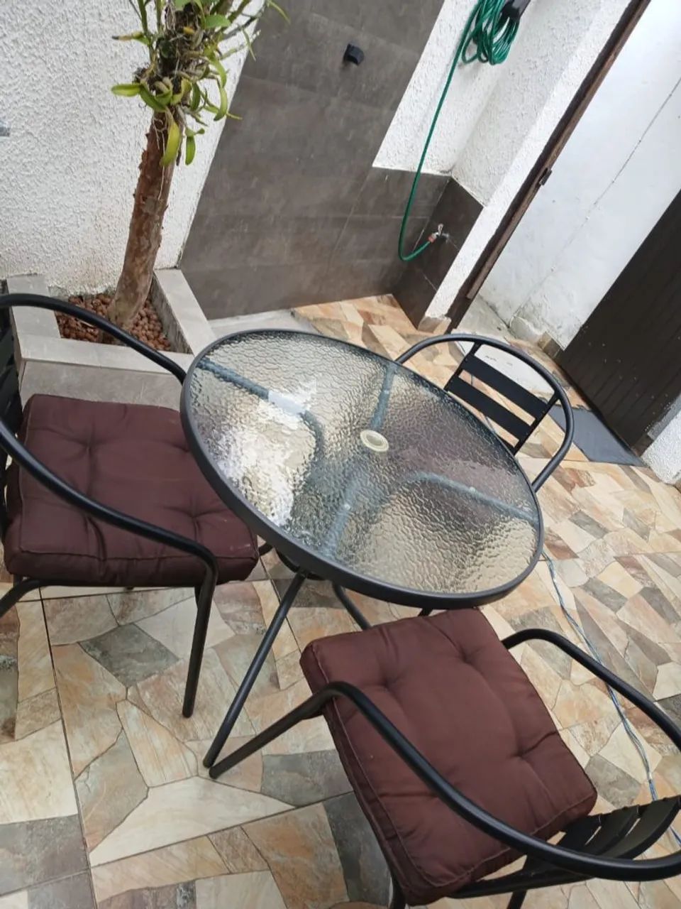 Mesa com vidro e três cadeiras com almofadas 