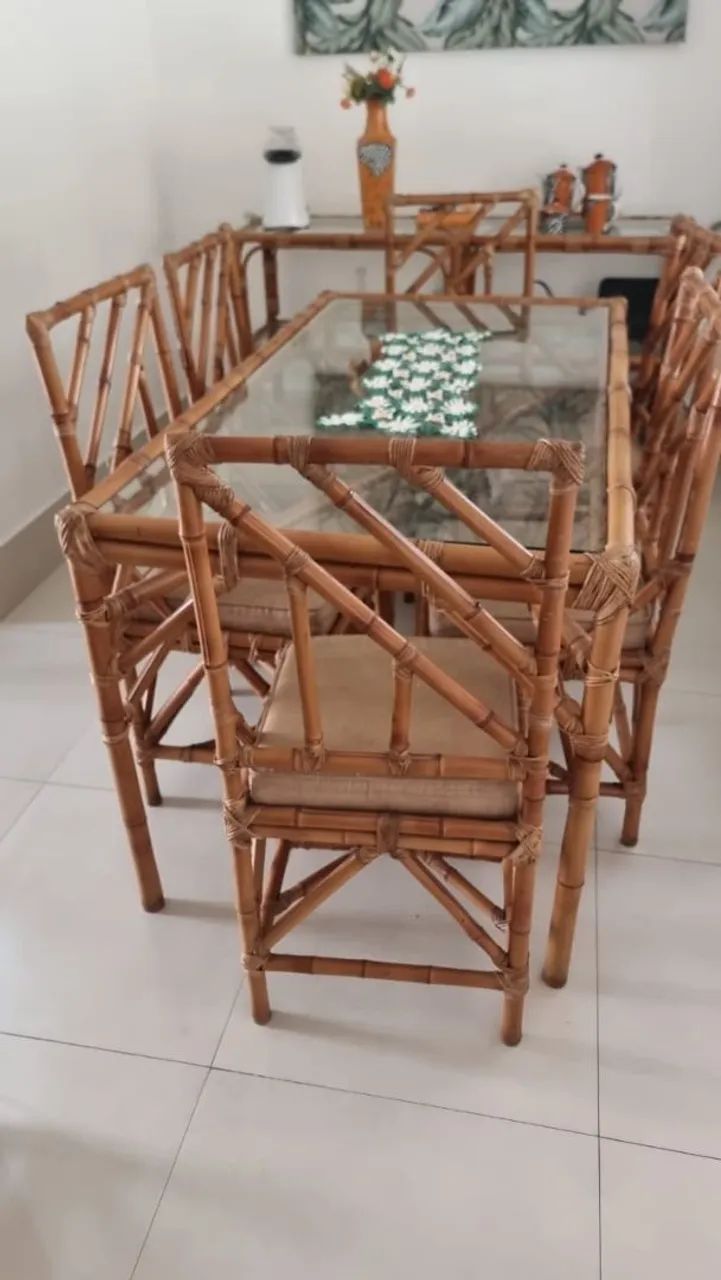 Mesa retangular com seis cadeiras, aparador e masinha lateral, todos em bambu e vidro.